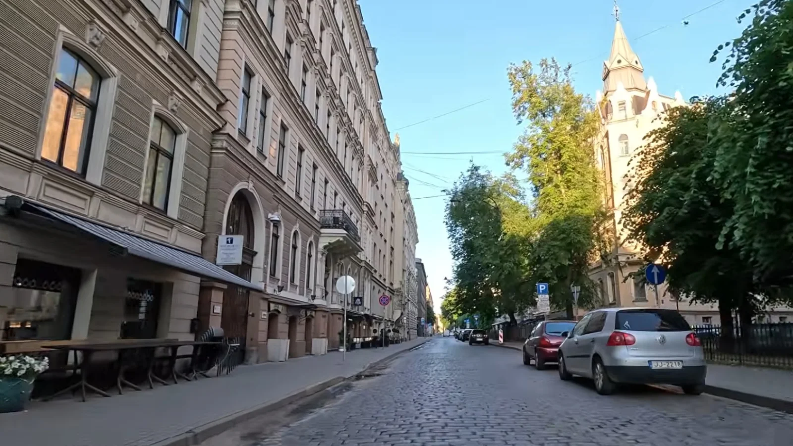 Quiet historic street with parked cars, trees and summer light in central Riga