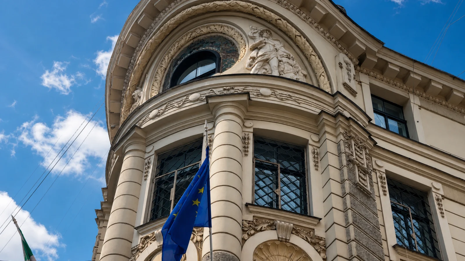 Ornate historic building with a European Union flag under a blue summer sky in Riga