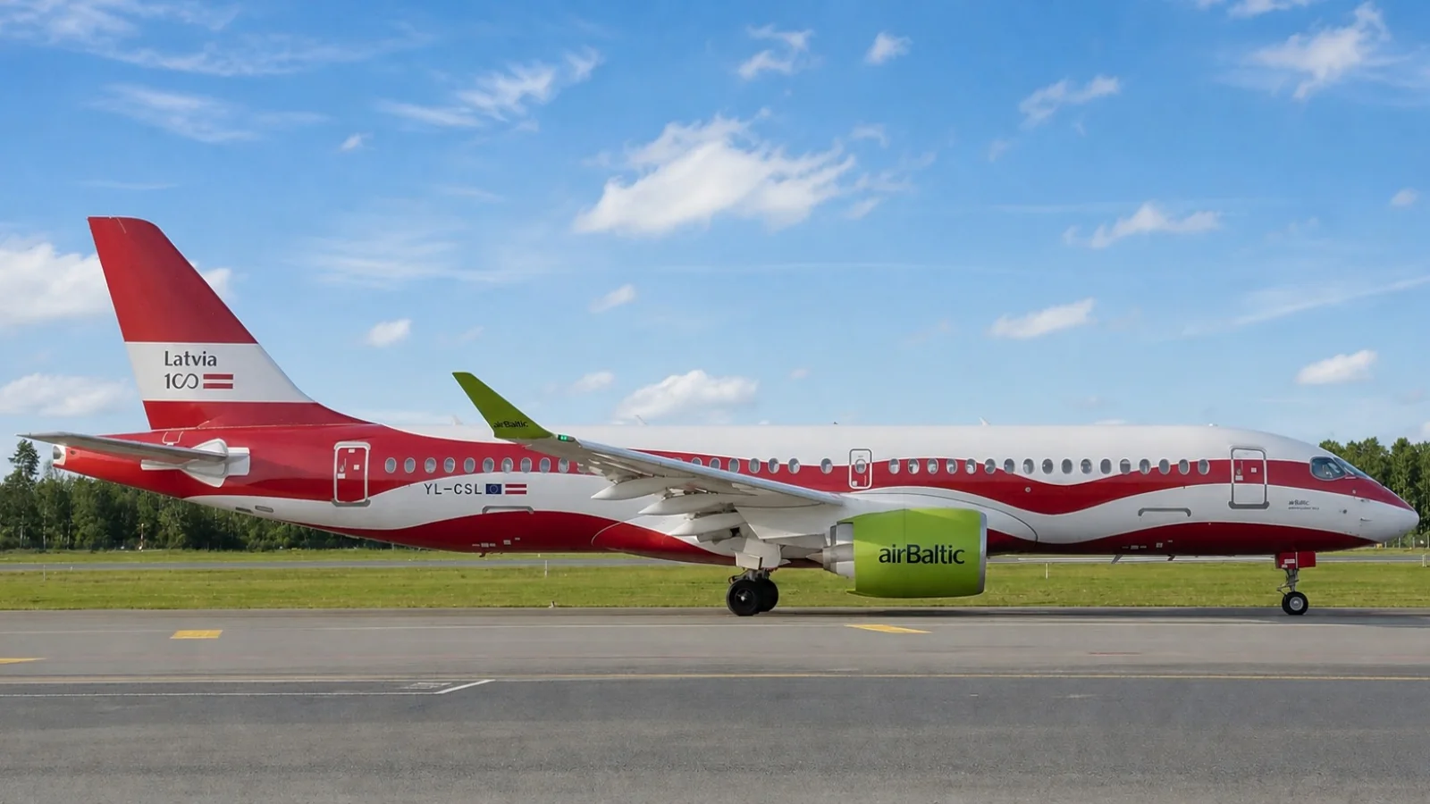 Side view of an airBaltic aircraft in red-and-white Latvia centenary livery on a runway